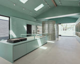 Modern retail store with light green cabinets and a glass island.