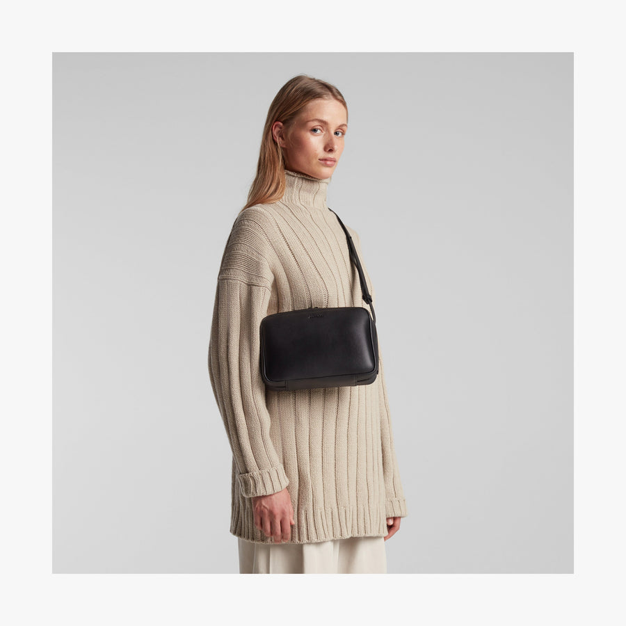 Carbon Black (Vegan Leather) | Angled view of Metro Crossbody in Carbon Black