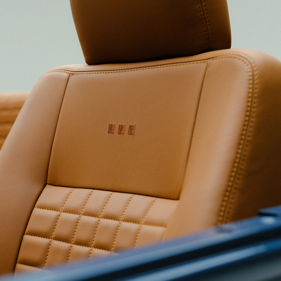 Arles Blue | Saddle Tan leather seat with Monos logo embroidery