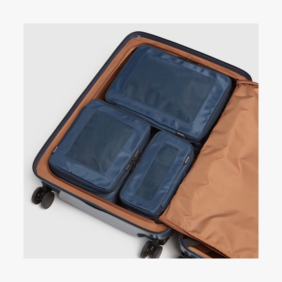 Set of Four / Arles Blue | Photo of compressible packing cubes neatly arranged inside a suitcase