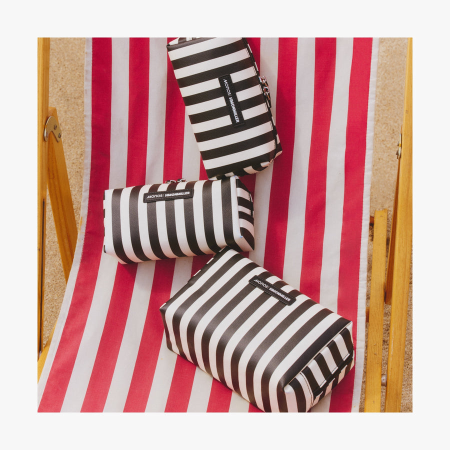 Small / Poplin Stripe Black | Three Metro Toiletry Cases in Poplin Stripe Black displayed on a red and white striped beach chair