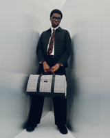 The Monos Metro Carry-All Duffel in Houndstooth Check, styled in a sleek modern setting. A timeless travel essential crafted with premium materials and minimalist design—combining structure, sophistication, and versatility for any journey.